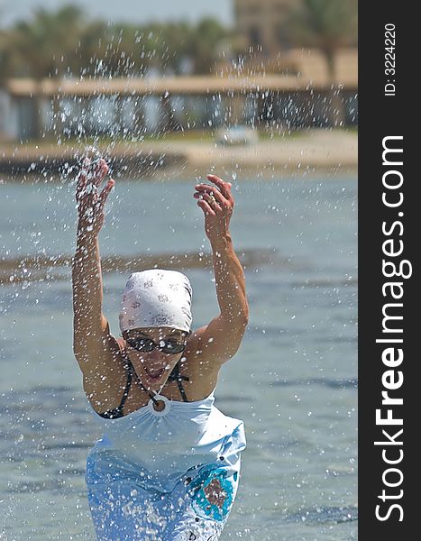 Woman being sprinkled at the seaside