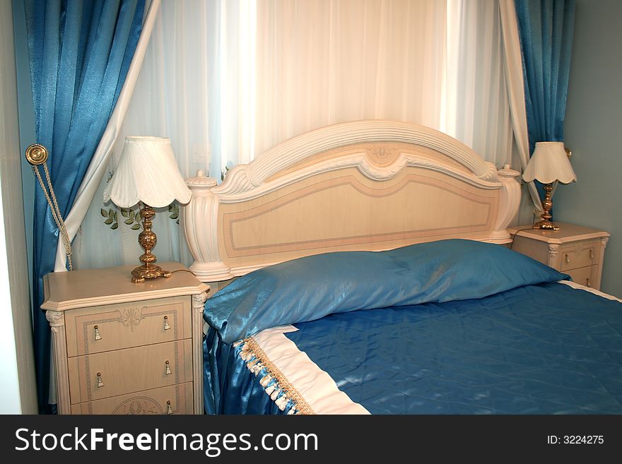 Nice blue bedroom with many  luxurious details.