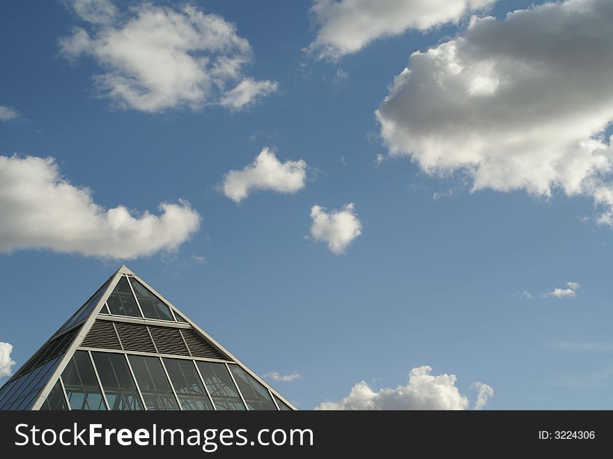 Glass Pyramid  Against a Cloudy Sky. Glass Pyramid  Against a Cloudy Sky