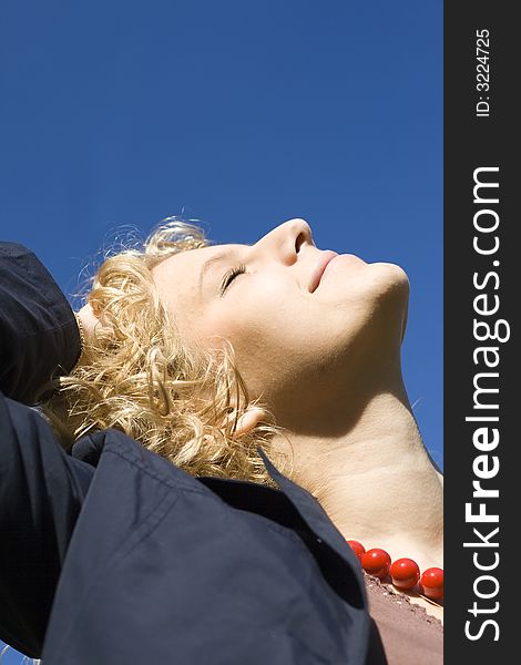 Smiling women with red necklace looks upwards. Smiling women with red necklace looks upwards