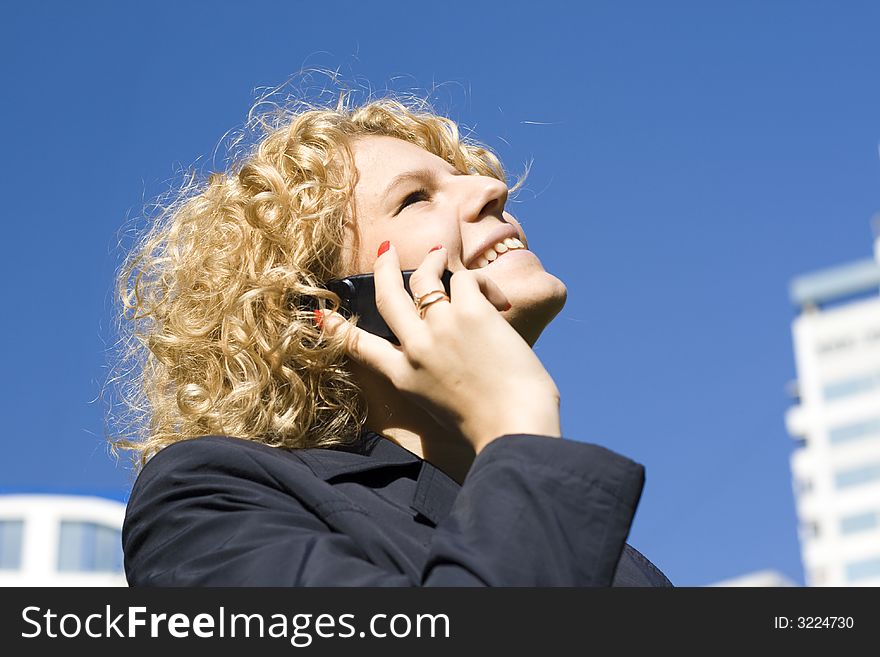 The business woman talks by a mobile phone. The business woman talks by a mobile phone