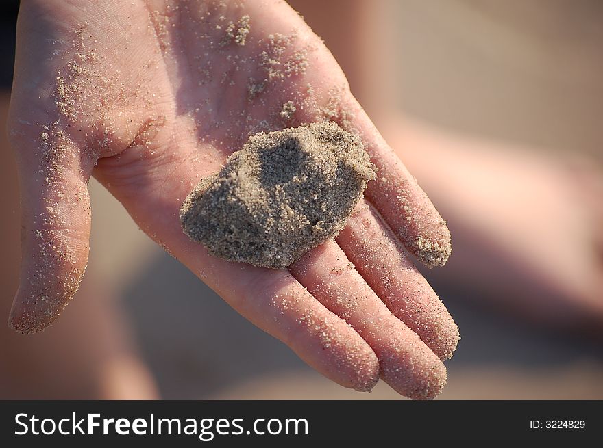 Close-up of a child's hand containing sand. Close-up of a child's hand containing sand