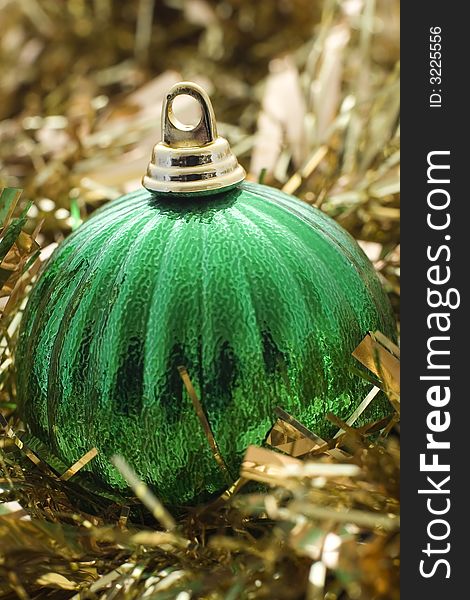 A green christmas decoration with gold tinsel
