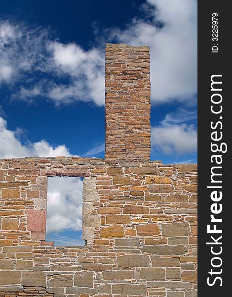 Window and chimney tower in ruined form against cloud and blue sky. Window and chimney tower in ruined form against cloud and blue sky