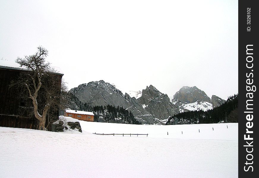 A barn in front of the Alps of eastern Switzerland. A barn in front of the Alps of eastern Switzerland.