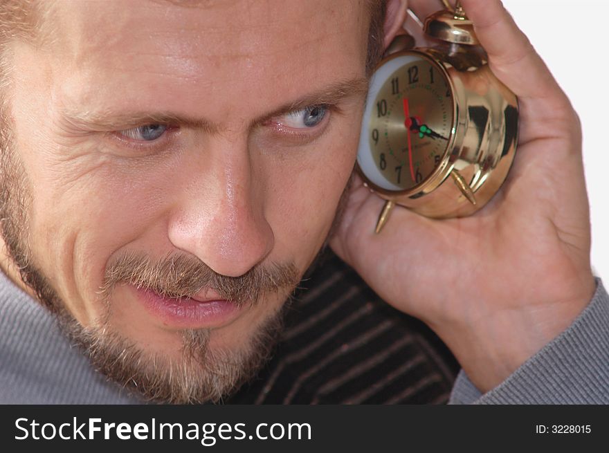 A businessman listening to an alarm clock sound. A businessman listening to an alarm clock sound