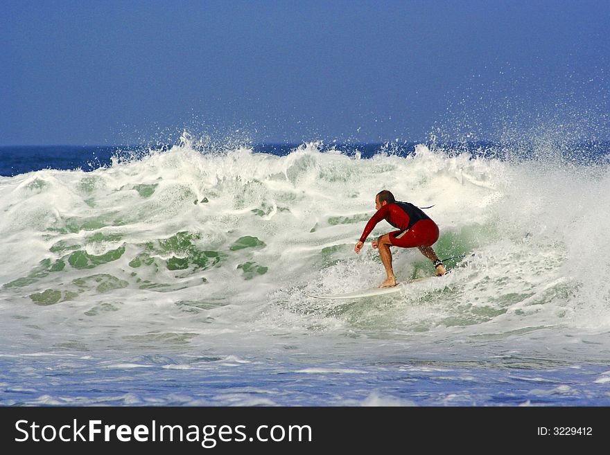 An image of a surfer doing a maneuver in the wave.