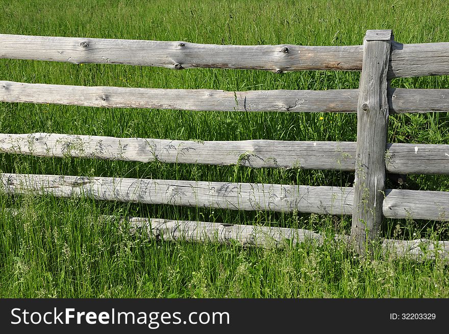 Wooden fence on the background of green grass. Wooden fence on the background of green grass.