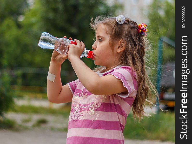 Girl drinks water from a bottle