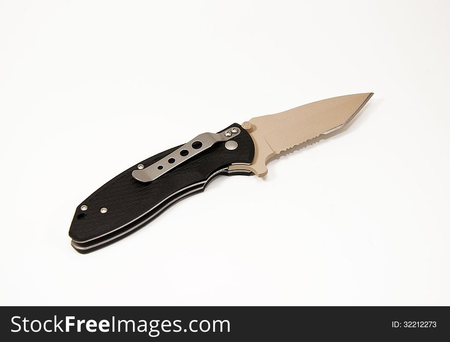 Single black stainless steel handled tactical folding knife with beige coated stainless steel blade and silver pocket clip against a white background. Single black stainless steel handled tactical folding knife with beige coated stainless steel blade and silver pocket clip against a white background