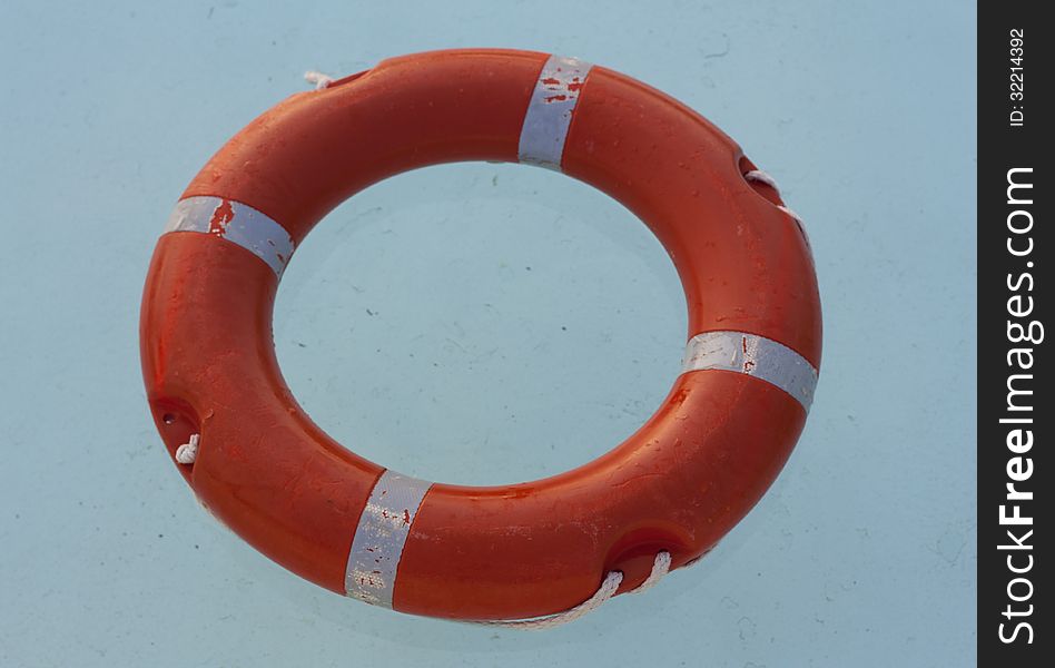 Safe water support aid circle with rope. Rescue red life buoy on wooden background of ship or boat. Helpful object. Safe water support aid circle with rope. Rescue red life buoy on wooden background of ship or boat. Helpful object.