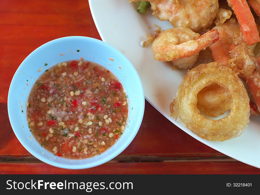 Fried vegetables and fried shrimp with sauce on table