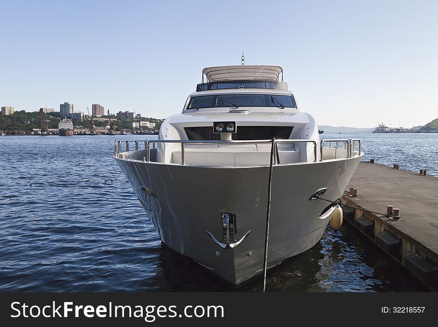 The boat at the mooring costs waiting for passengers in the light of a bright sun