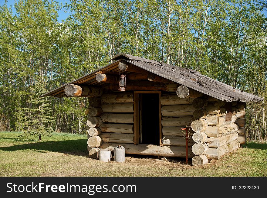 Outside of Trappers Log Cabin with lantern and other tools.