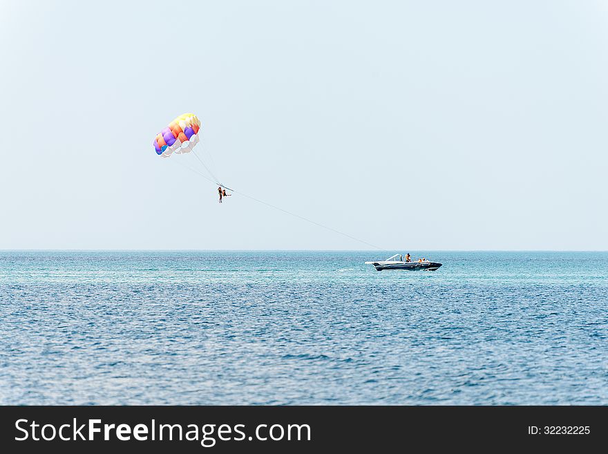 Vacationers try out the water sport of parasailing