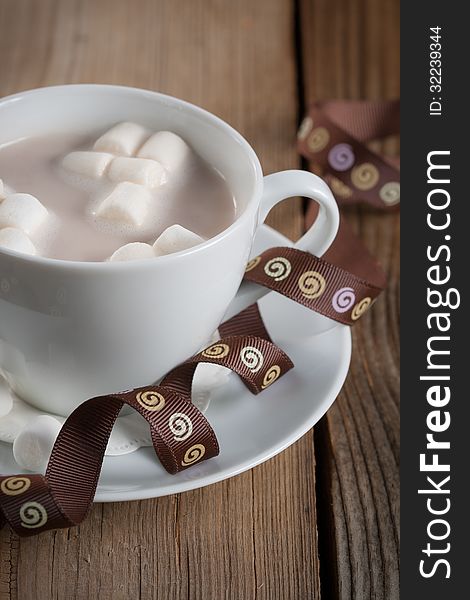Marshmallows in a cup of Hot Chocolate on a wooden table. Marshmallows in a cup of Hot Chocolate on a wooden table