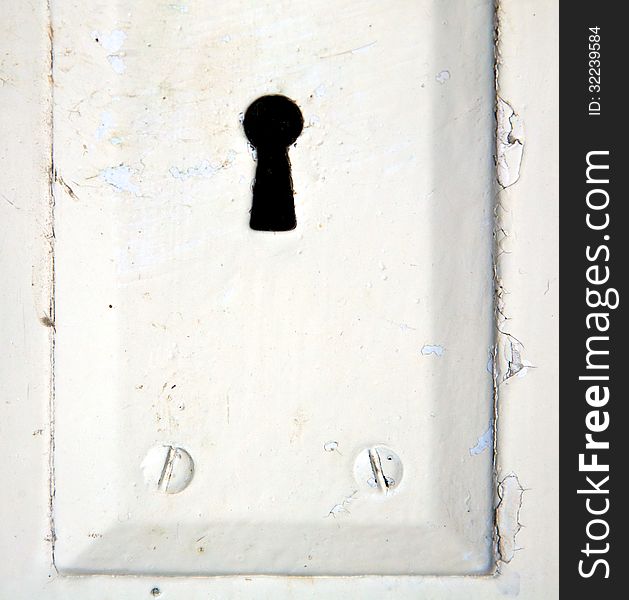 An antique key hole on an old weathered door. An antique key hole on an old weathered door