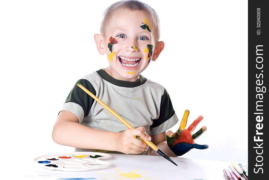 Boy paints watercolors paints on a sheet of paper. Boy paints watercolors paints on a sheet of paper