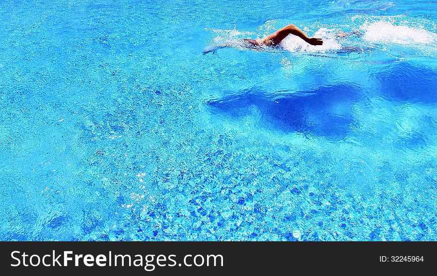 Sports and Activities. A man swims in the pool.