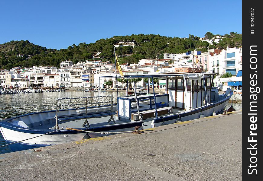 Pier in the harbor, moored fishing boat.