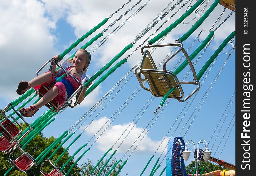 Girl riding a chained carousel