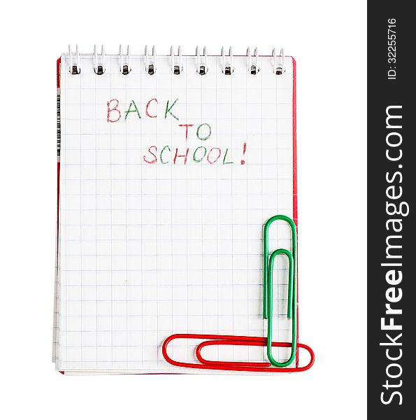 Notebook with phrase Back to school with red and green clips isolated