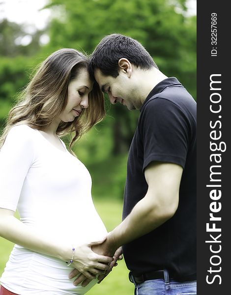 Pregnant couple in love holding pregnant belly. Pregnant couple in love holding pregnant belly