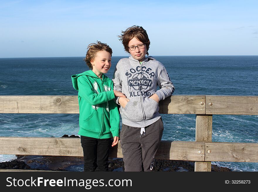 A six-year-old-girl and her twelve-year-old-brother stand with the strong wind blowing their hair at The Nobbies, Phillip Island. A six-year-old-girl and her twelve-year-old-brother stand with the strong wind blowing their hair at The Nobbies, Phillip Island