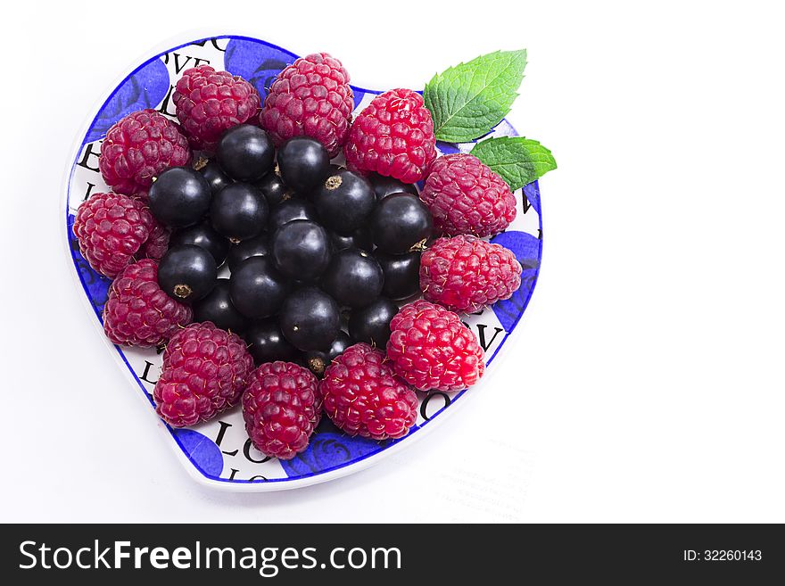 Raspberries And Black Currant On The Beautiful Saucer