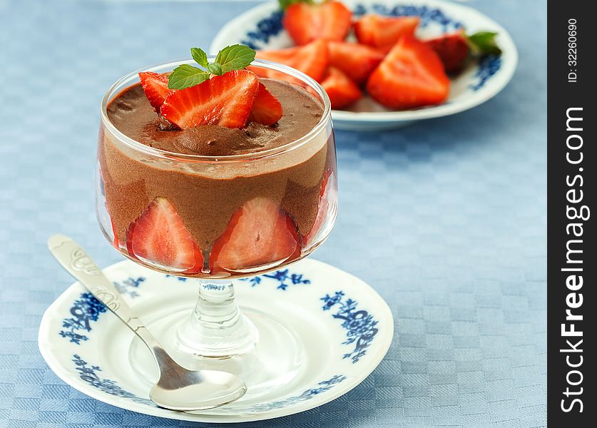 Photo of delicious chocolate mousse with strawberries on blue napkins. Photo of delicious chocolate mousse with strawberries on blue napkins