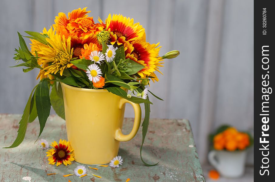 Bouquet of summer flowers in a vase before wooden background. Bouquet of summer flowers in a vase before wooden background