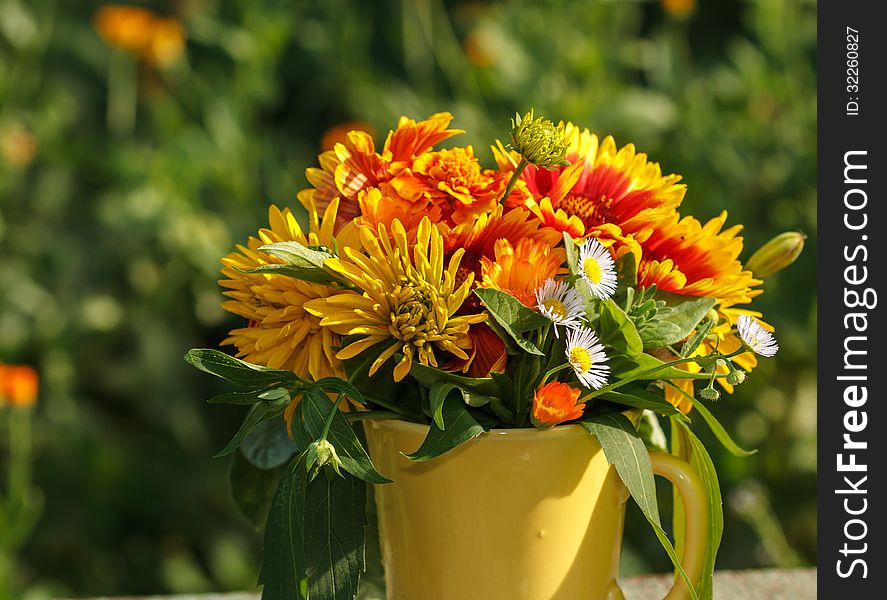 Bouquet of summer flowers in a yellow mug. Bouquet of summer flowers in a yellow mug