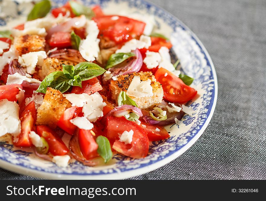 Rustic tomatoes salad in vintage blue plate