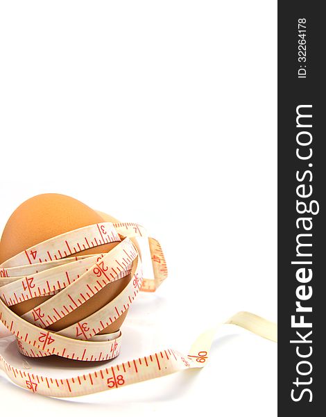 Measurement Tape Wrapped Around The Egg on white background. Measurement Tape Wrapped Around The Egg on white background.
