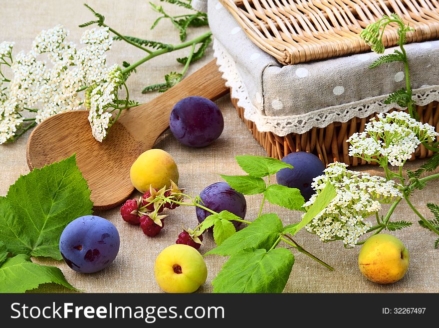Ripe fruits, wild flowers and basket on the table in the garden. Ripe fruits, wild flowers and basket on the table in the garden