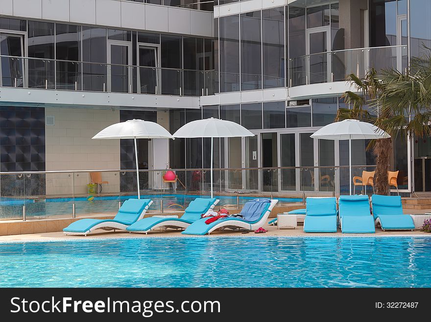 Lounge chairs with umbrella near the swimming pool