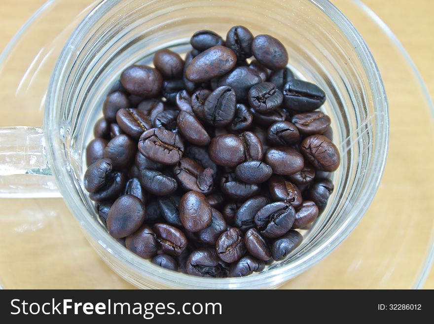 Coffee beans in cup on the wood table