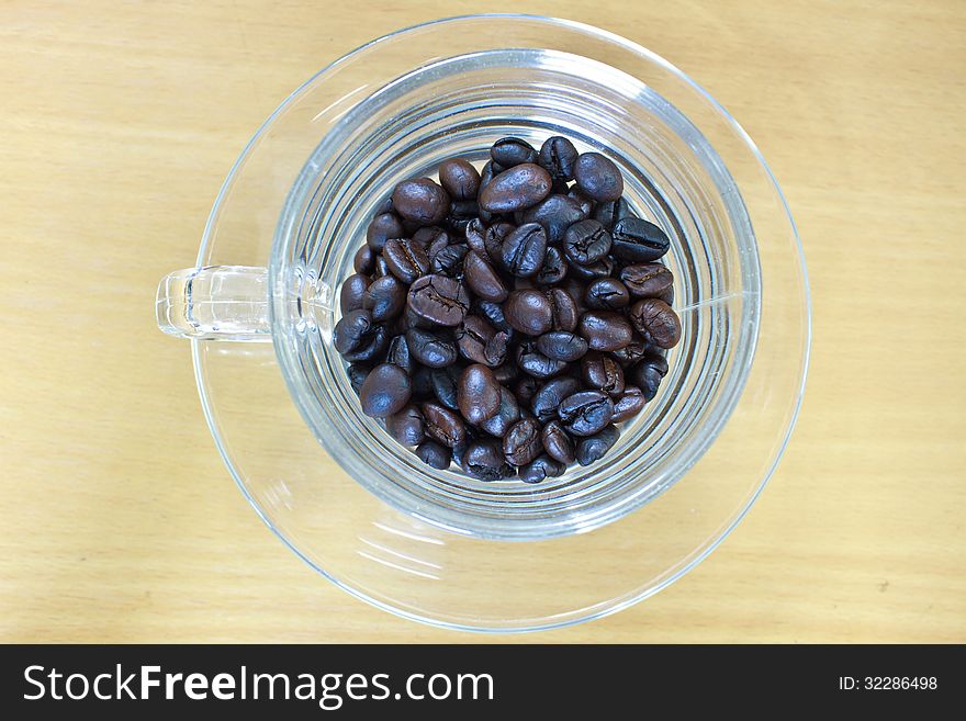 Coffee beans in cup on the wood table