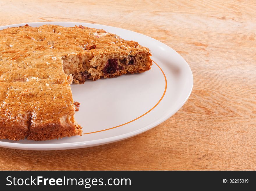 Homemade cake with cut piece on a wooden table