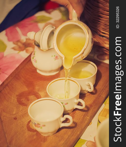 Horizontal photo, of the teapot tea flow in cup, tea ceremony