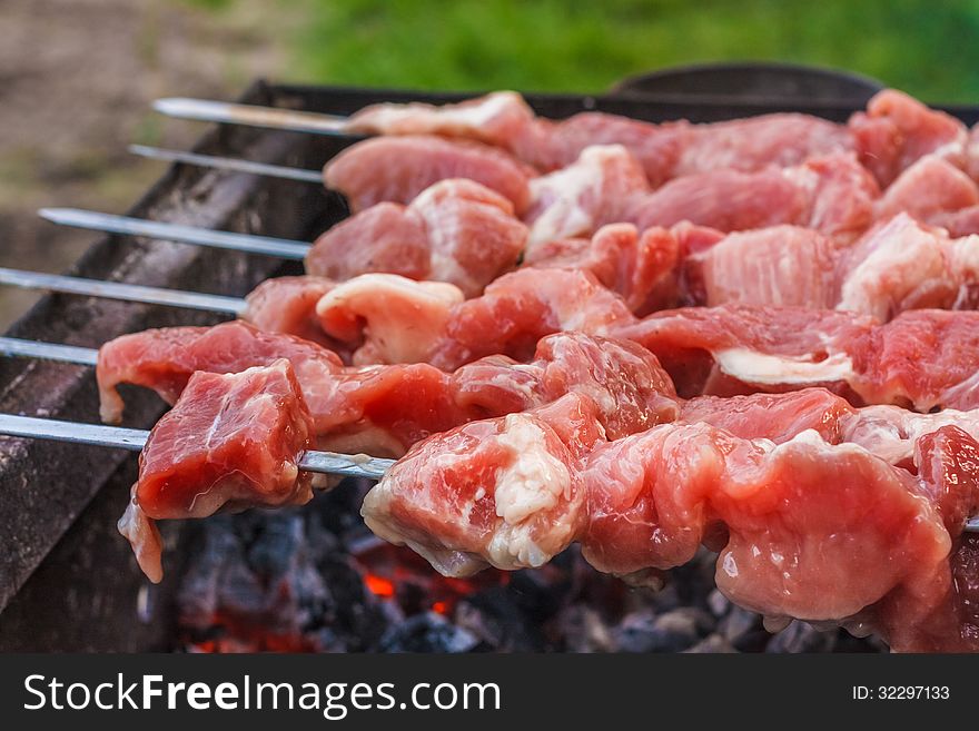 Shish kebab in process of cooking on open fire outdoors