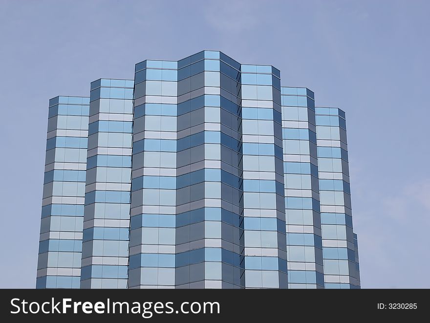 Many angled blue office building against blue sky. Many angled blue office building against blue sky