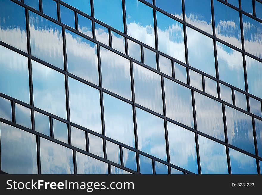 Reflections of blue sky and white clouds in glass wall of an office building, taken in Frankfurt, Germany. Reflections of blue sky and white clouds in glass wall of an office building, taken in Frankfurt, Germany.