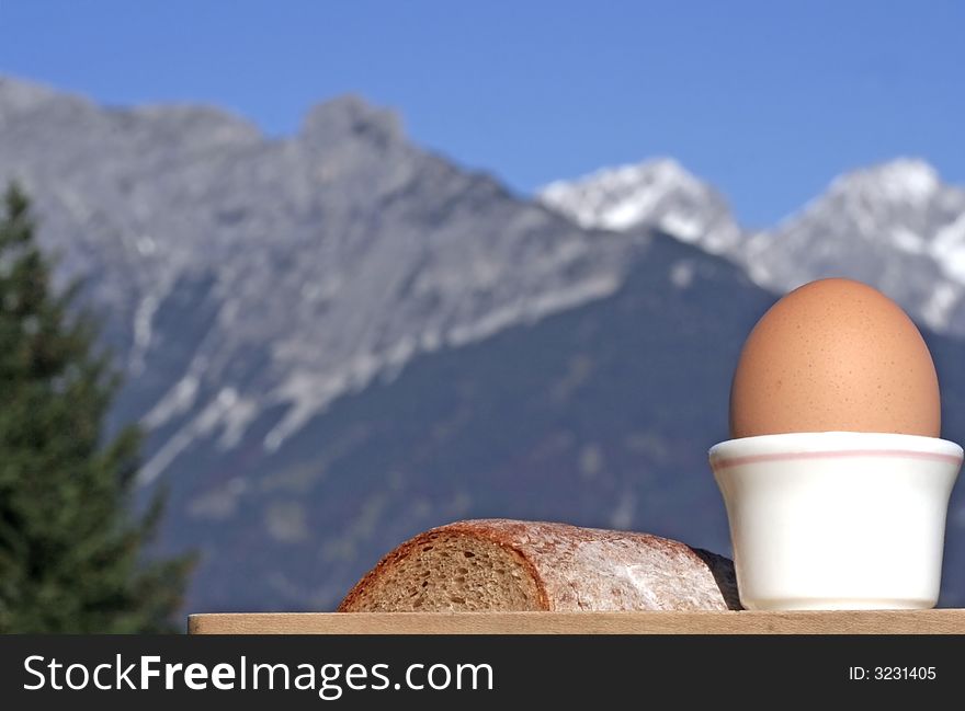 Close-up of egg and bread with alpine mountain range blurred in the background. Close-up of egg and bread with alpine mountain range blurred in the background