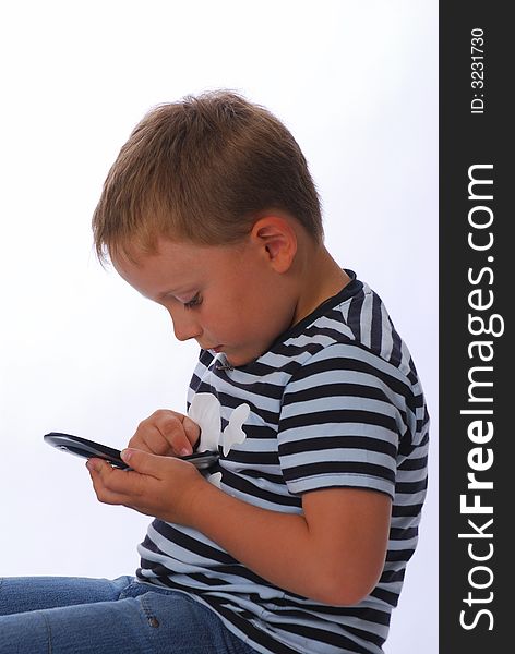 A boy with mobile phone on a white