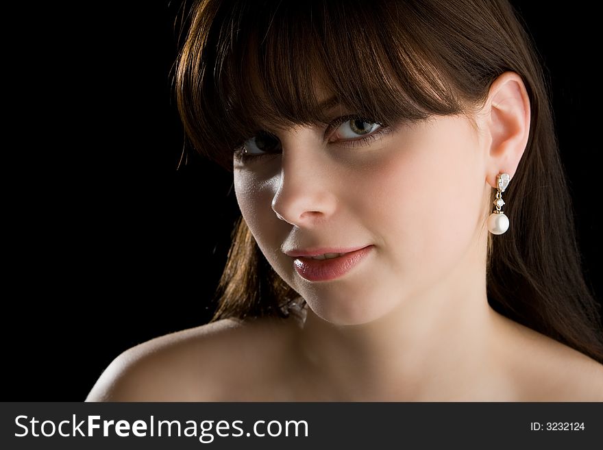 Brunette with earring on black background. Brunette with earring on black background