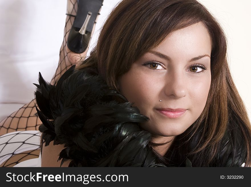 Attractive woman with boa feather scarf around her neck looking at camera. Attractive woman with boa feather scarf around her neck looking at camera