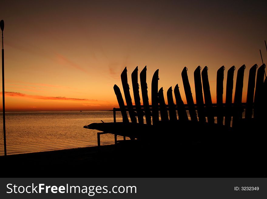 THis is a row of Kayaks in the sunset off of the causeway in Dunedin, FL.  The background is Honeymoon Island. THis is a row of Kayaks in the sunset off of the causeway in Dunedin, FL.  The background is Honeymoon Island.