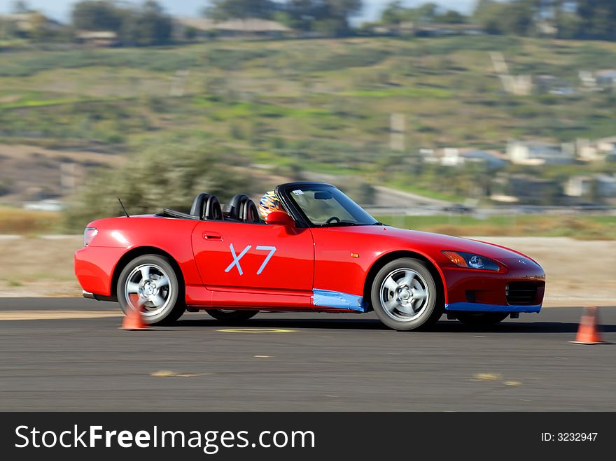 Red japanese sports car competing in autocross race. Red japanese sports car competing in autocross race