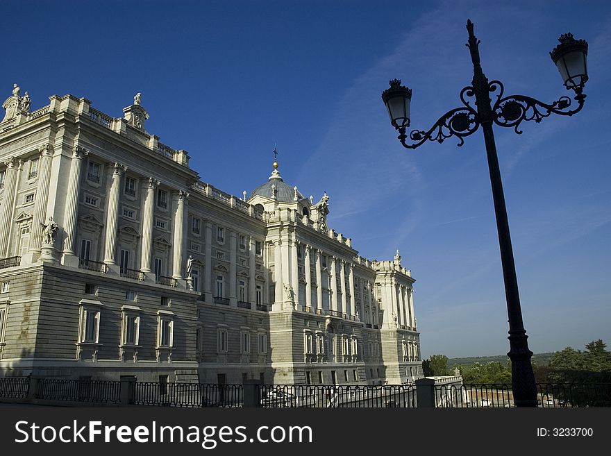 The Royal Palace in the morning light framed with a typical lamppost, in Madrid, Spain. The Royal Palace in the morning light framed with a typical lamppost, in Madrid, Spain.